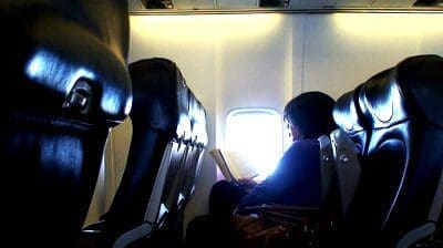stock footage woman reading a book whilst on a airplane flight