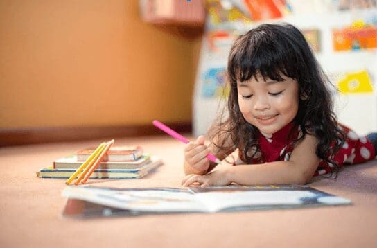 Young girl on floor with colouring pencil