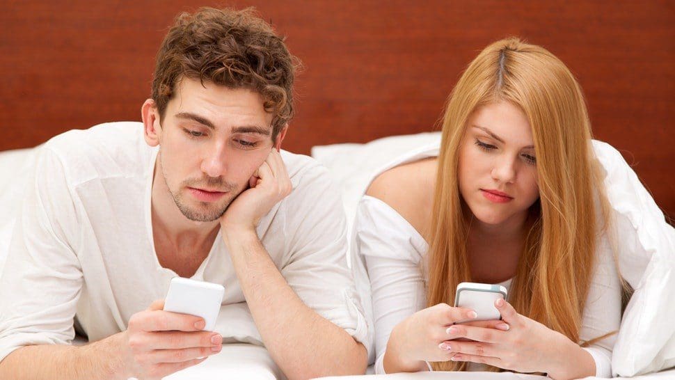 Man Woman Using Mobile On Bed