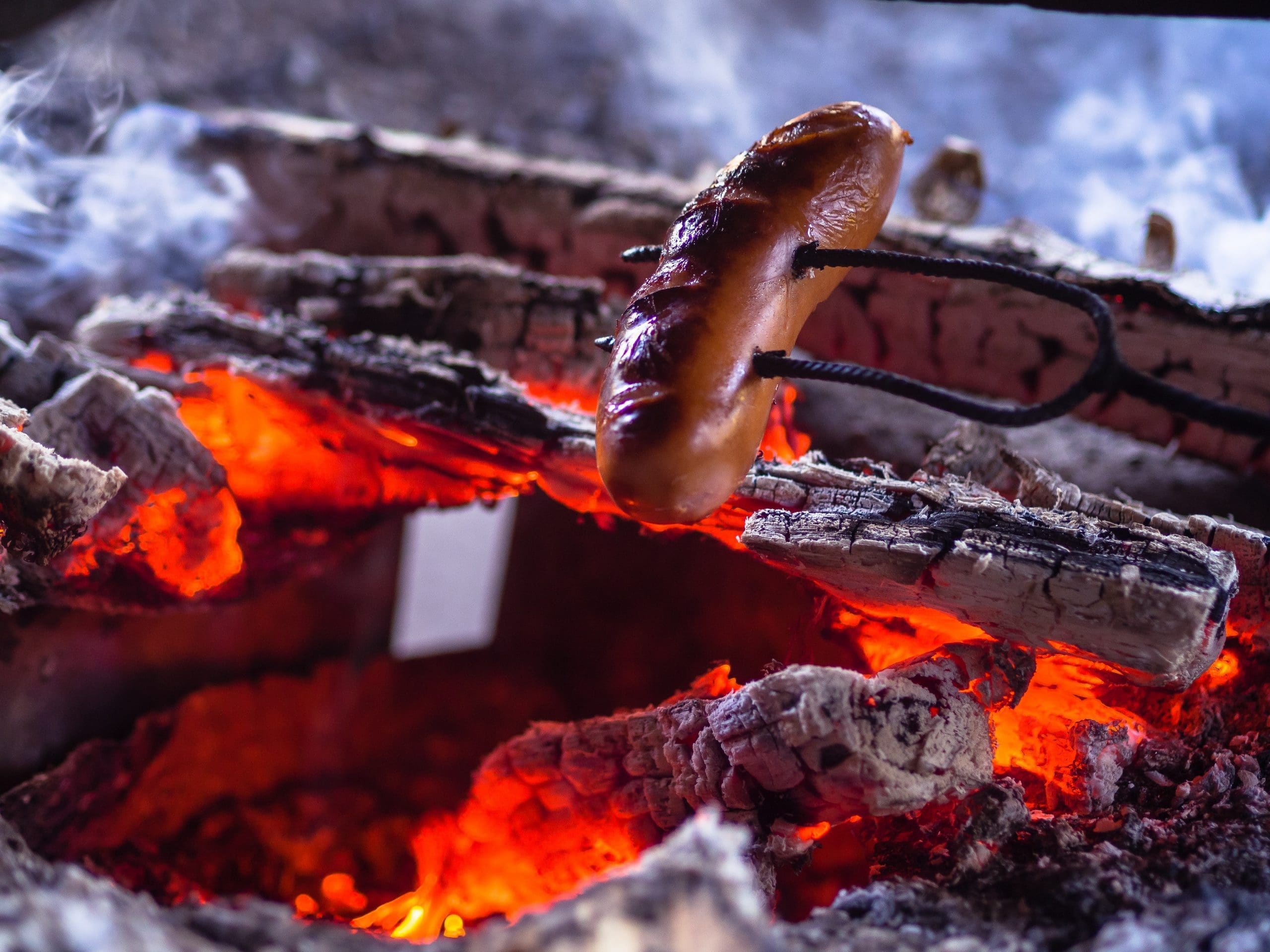 brown sausage on charcoal fire grill