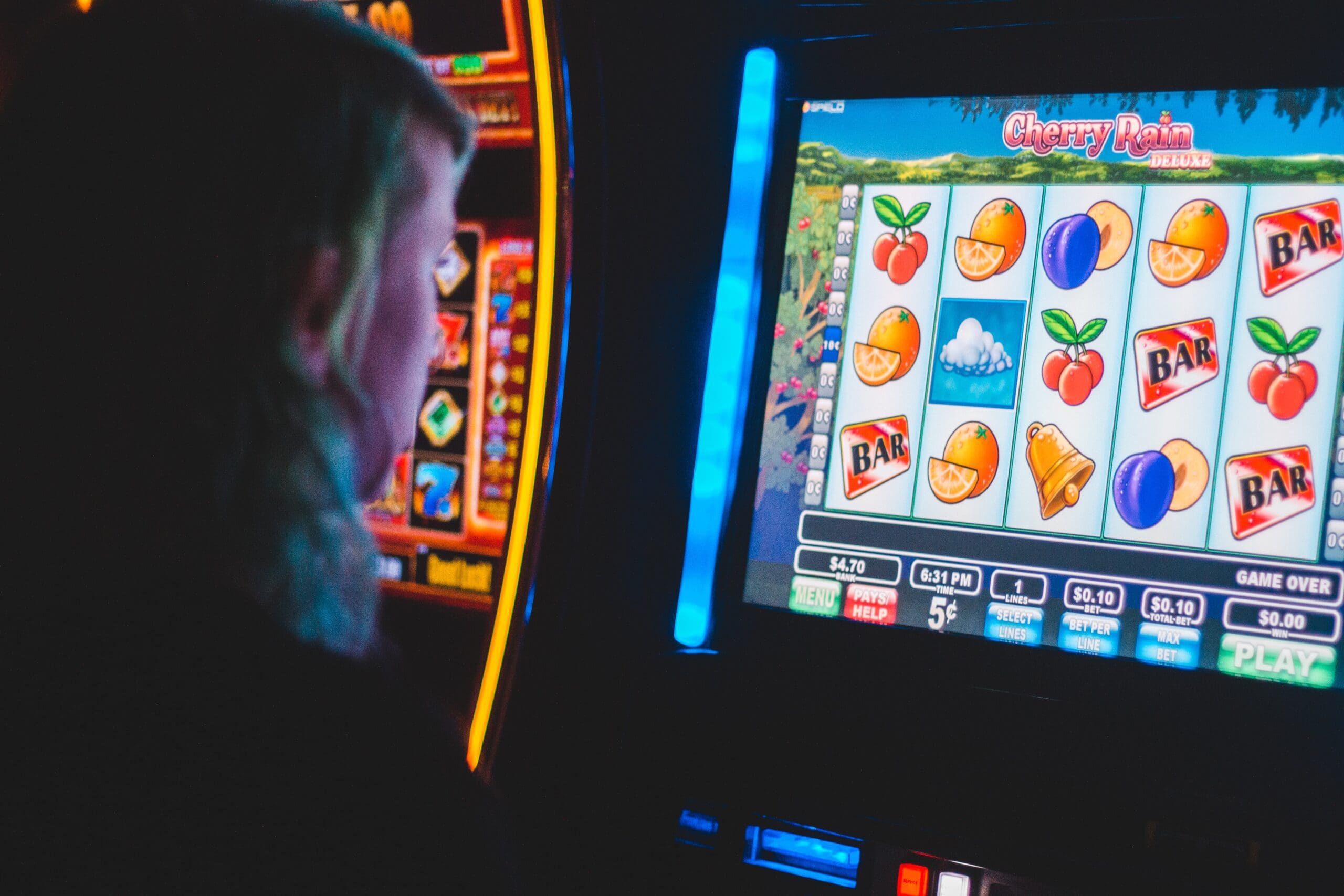 Photo by Erik Mclean man playing slot machine game