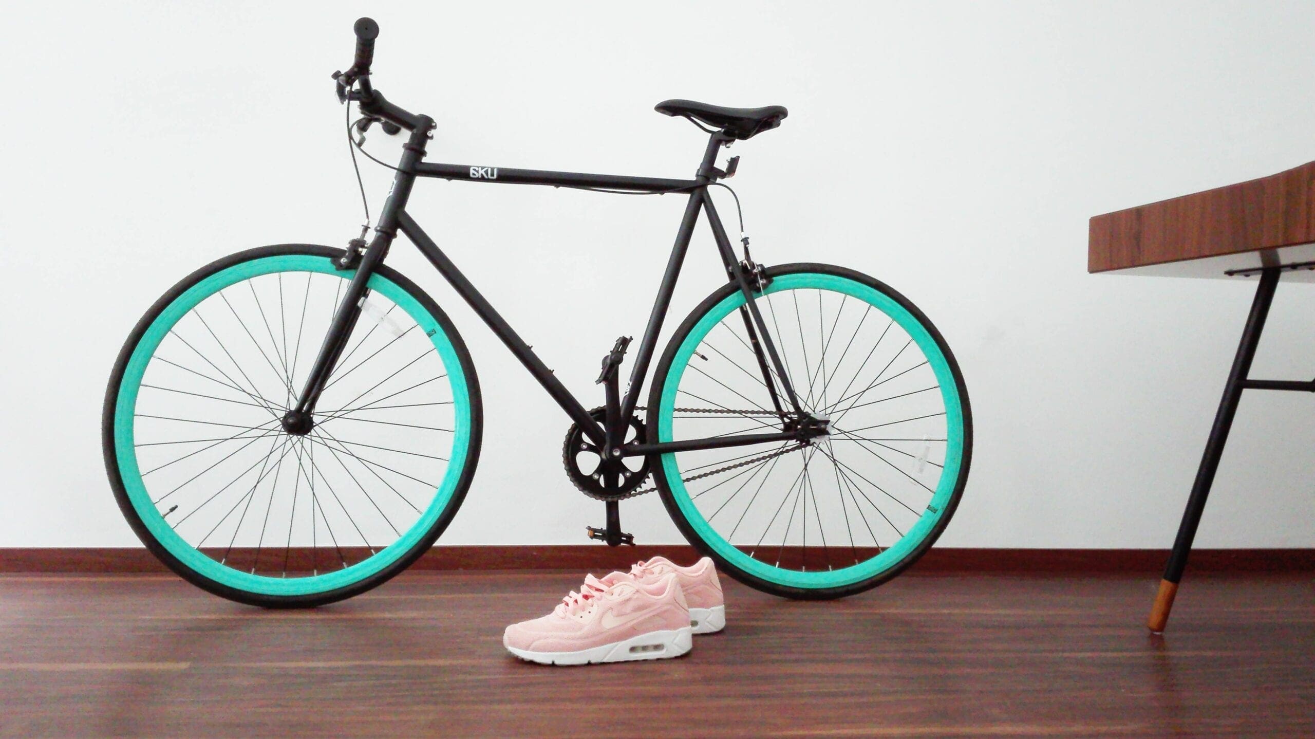 black and green road bike near pair of pink-and-white Nike Air Max Command folding exercise bike