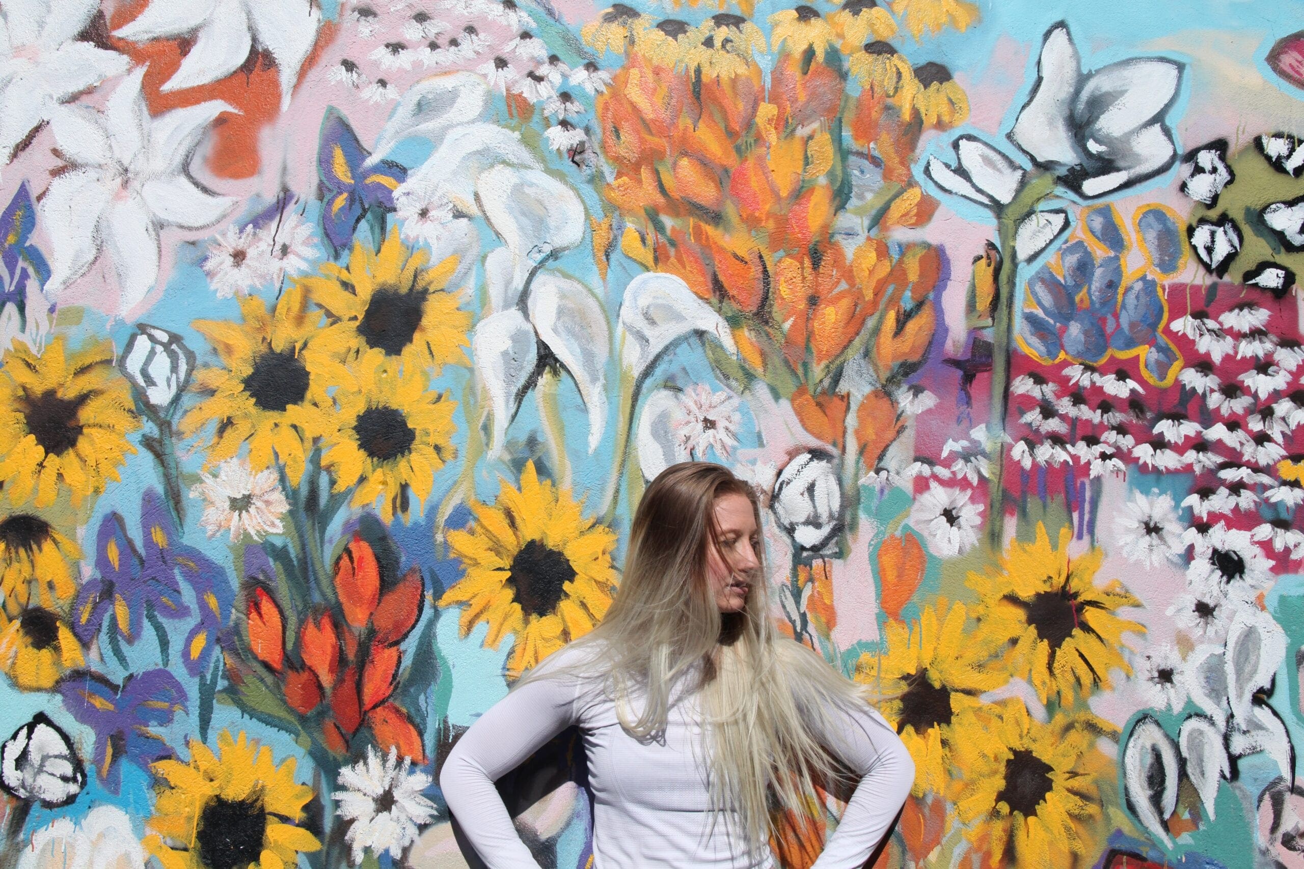 woman standing in front of graffiti wall tapestry