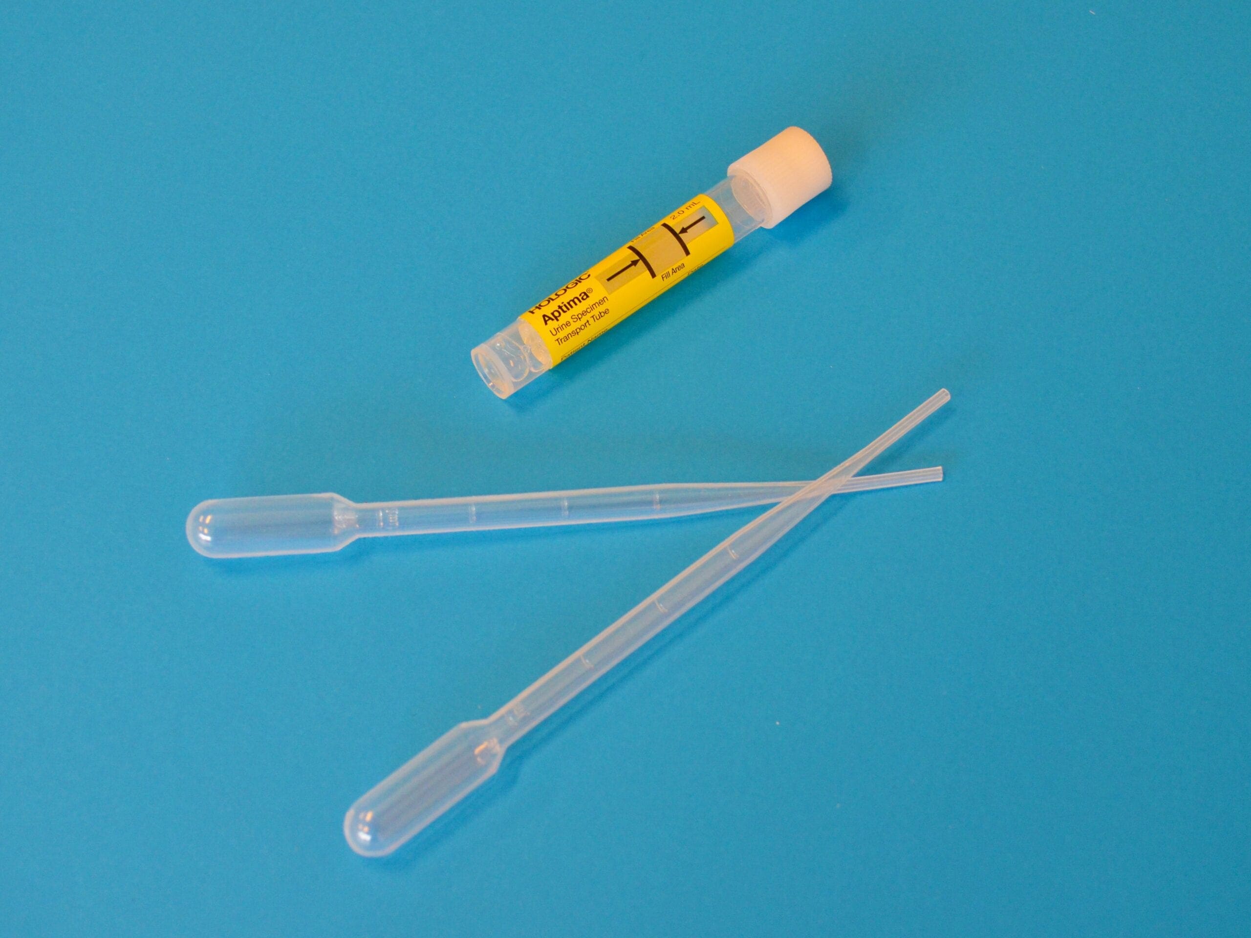 white ballpoint pen beside yellow and white plastic tool fake pee sample
