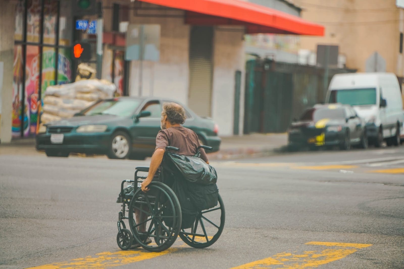 woman in gray shirt sitting on black wheelchair on road during daytime disability insurance