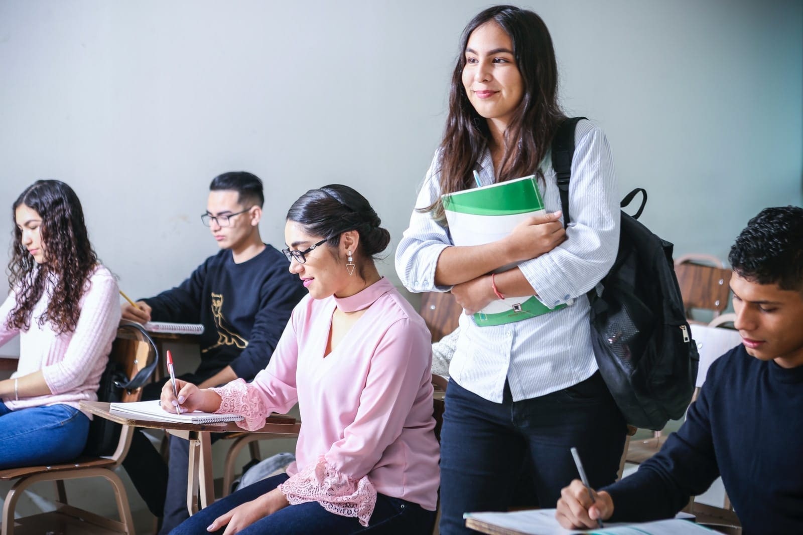 woman carrying white and green textbook College Student Mental Health