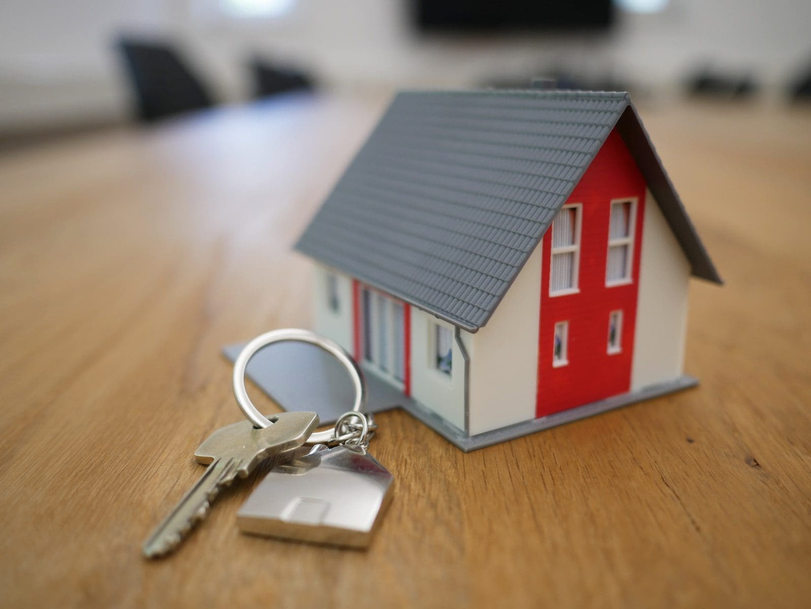 white and red wooden house miniature on brown table mortgage
