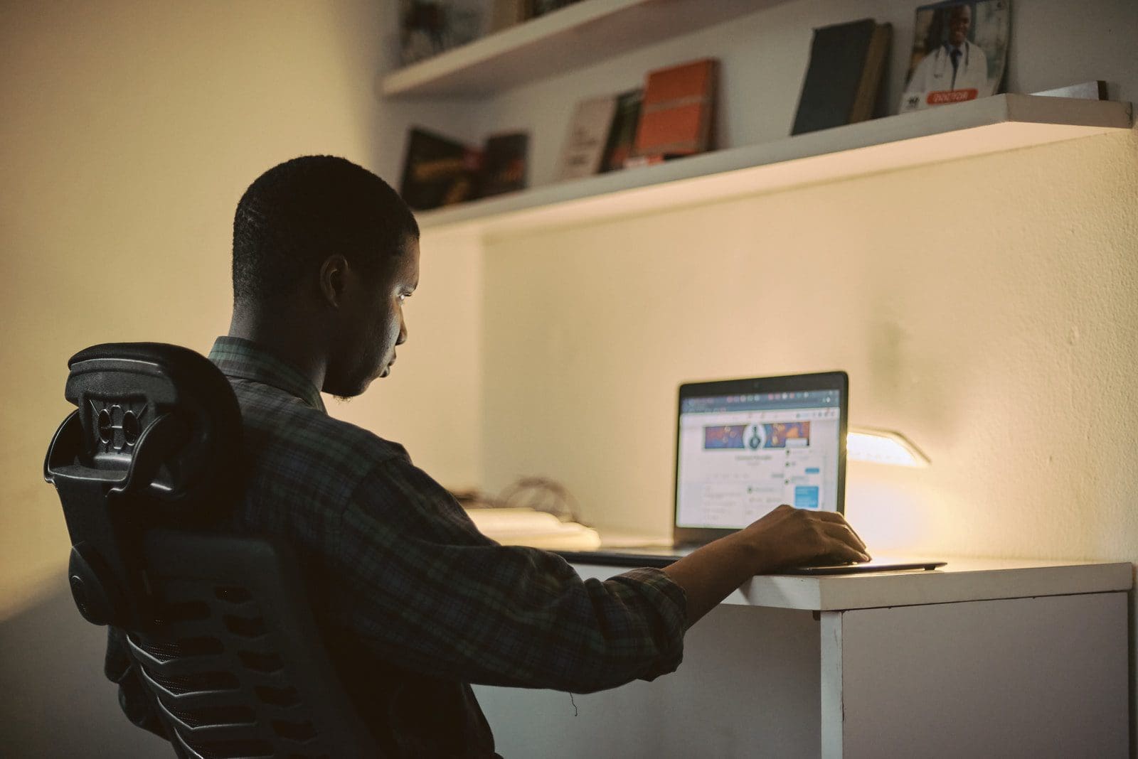 Photo by Emmanuel Ikwuegbu online degree man in black long sleeve shirt using macbook pro