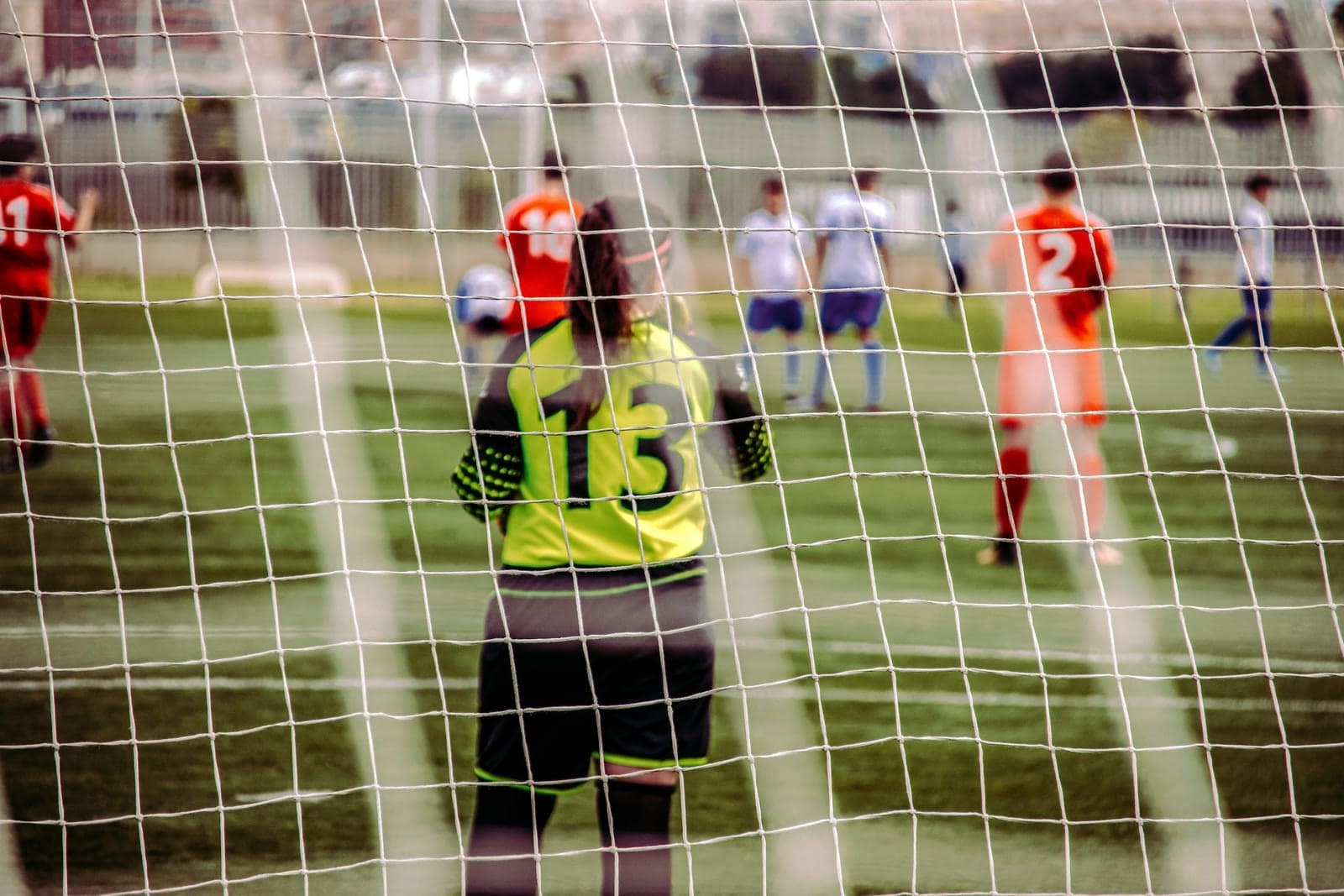 woman in yellow and black jersey shirt standing on field Apparel in Sport