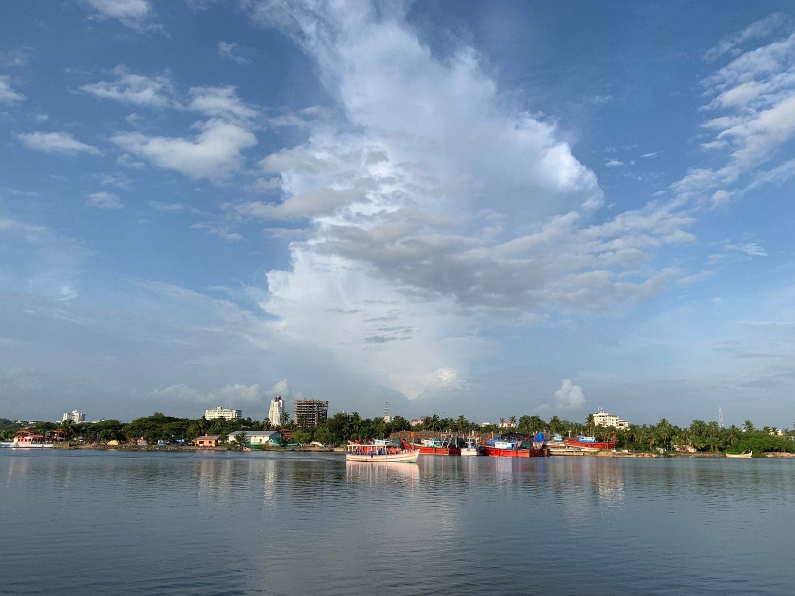 spring mangalore city with high-rise buildings near body of water under white and blue sky during daytime