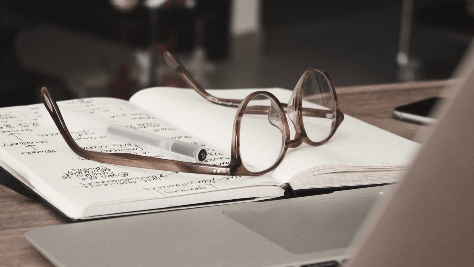 self-publish eyeglasses with gray frames on the top of notebook