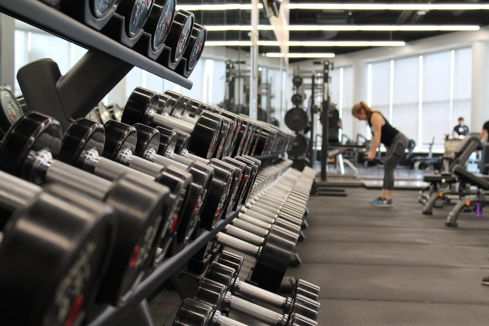 gym woman standing surrounded by exercise equipment