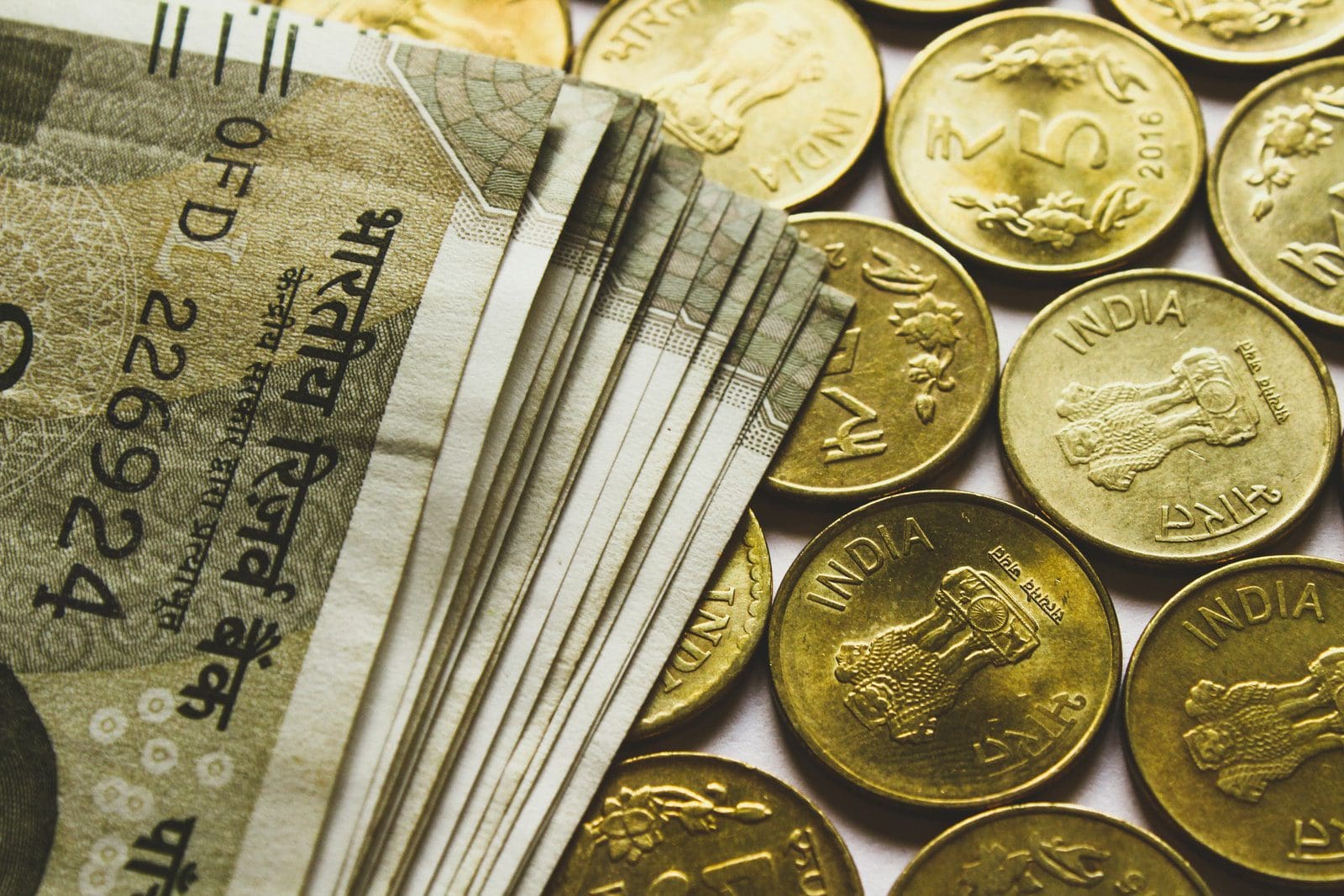 balanced funds round gold-colored rupee coins and banknotes