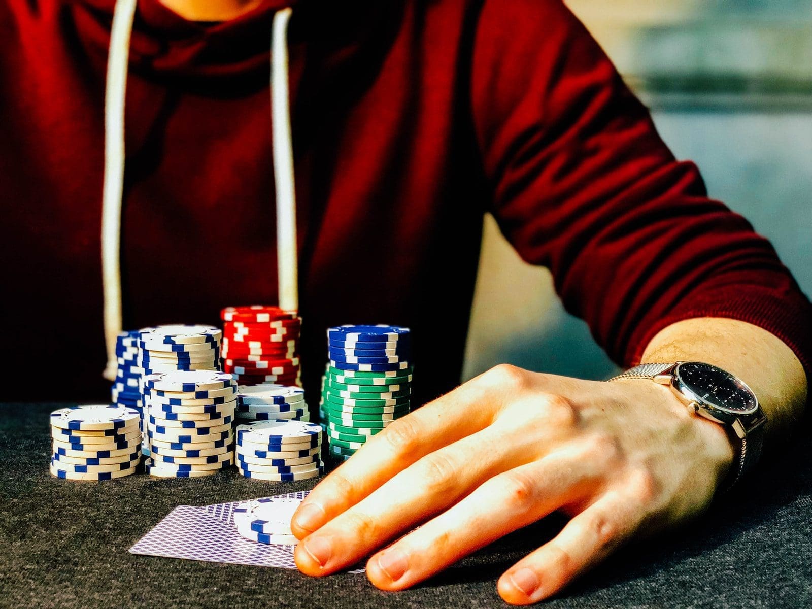 live gaming person holding playing cards beside poker chips