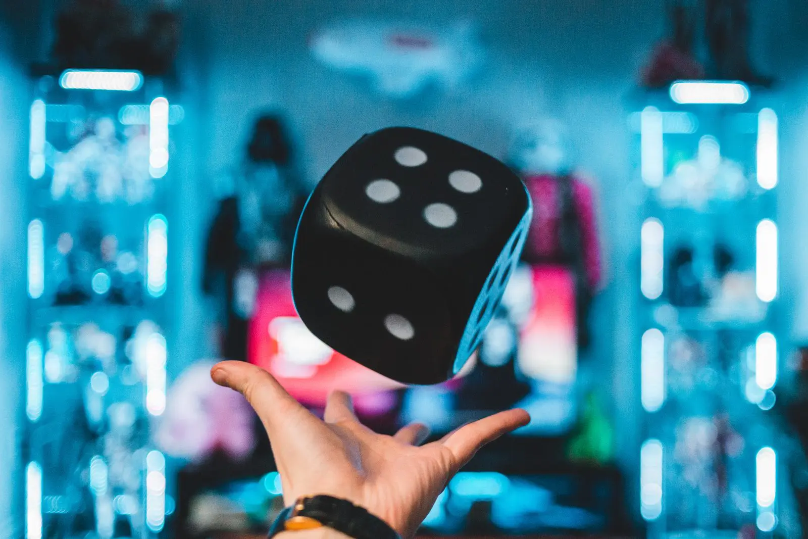 Photo by Erik Mclean person's left palm about to catch black dice