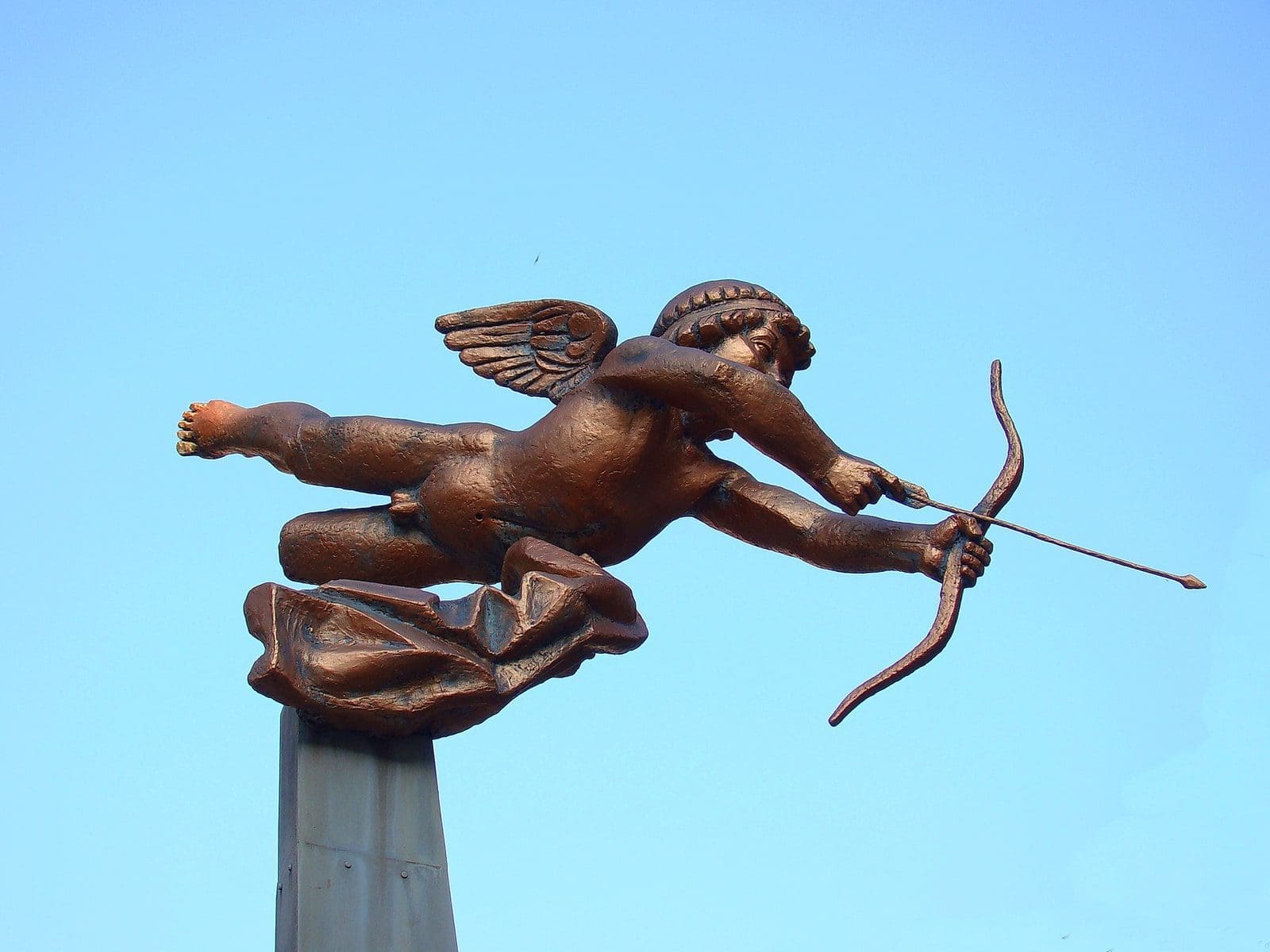 dating cupid app brown statue of man holding stick