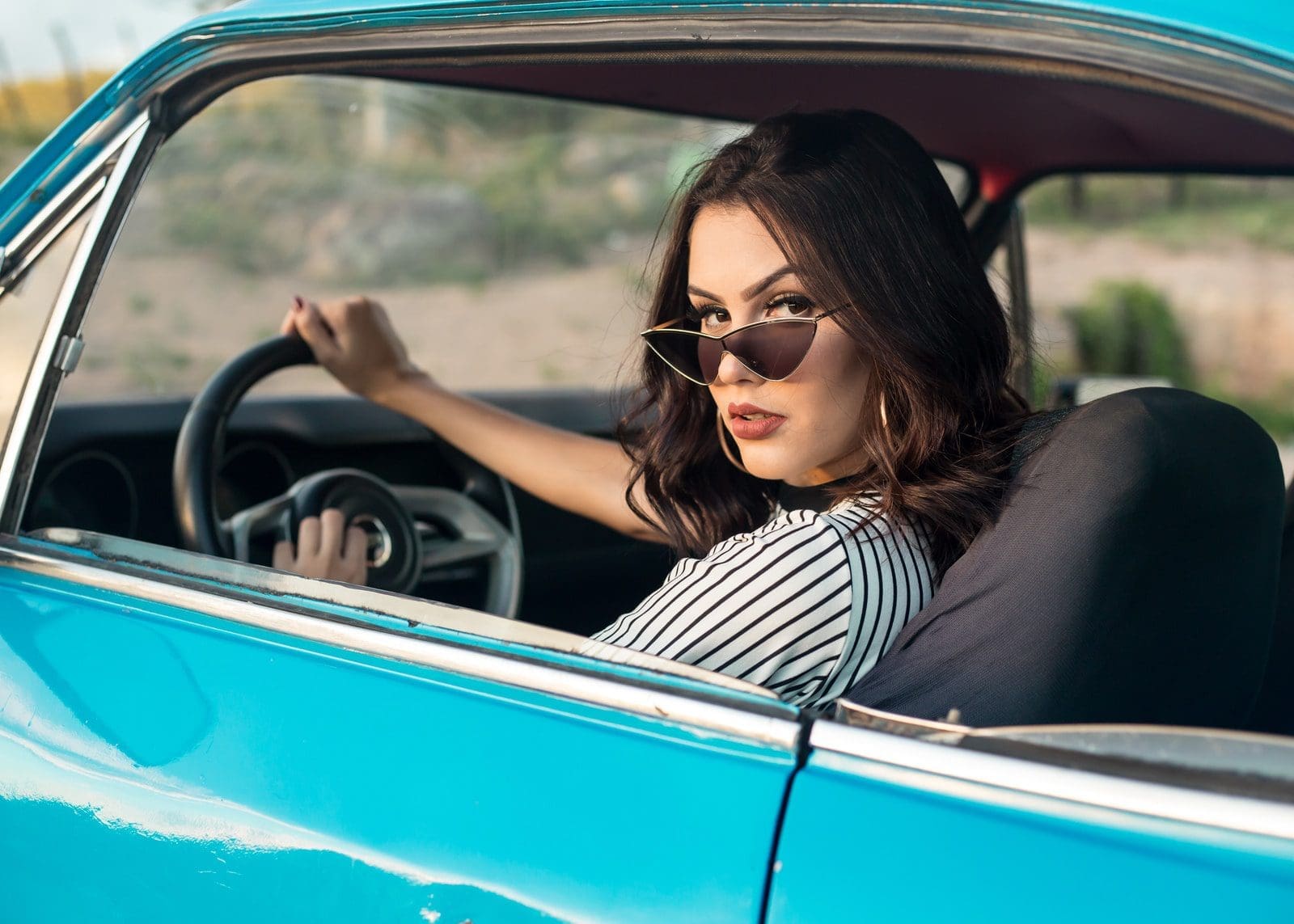 selective focus photography of woman driving blue car