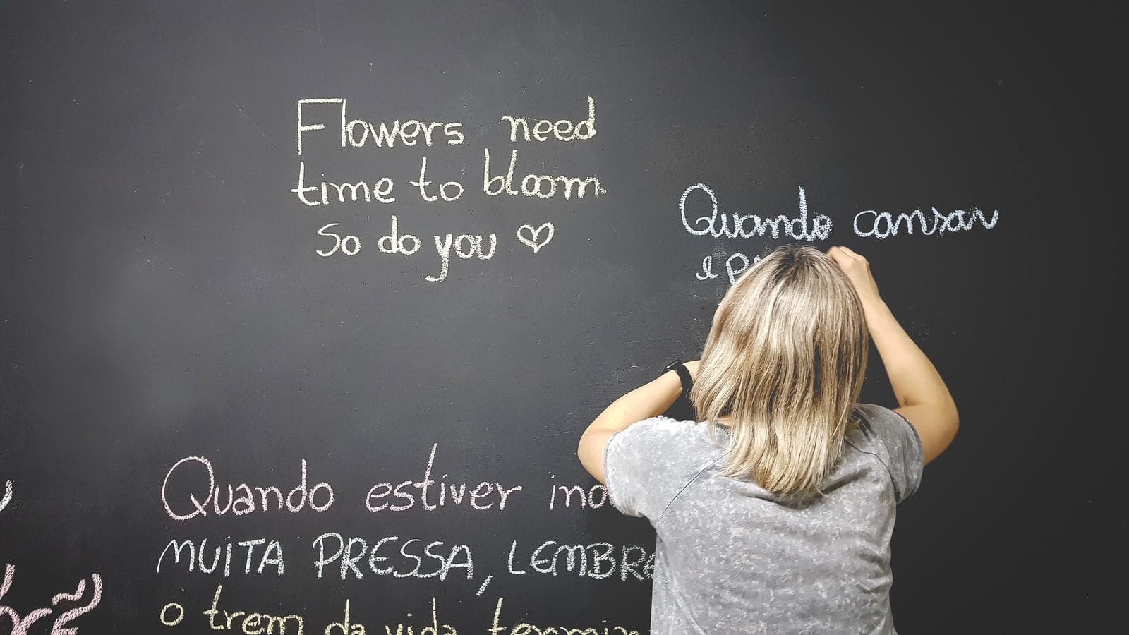 english teacher unknown person writing on chalkboard