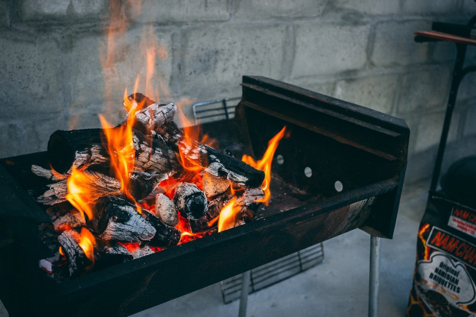 flaming charcoal fire on black grill