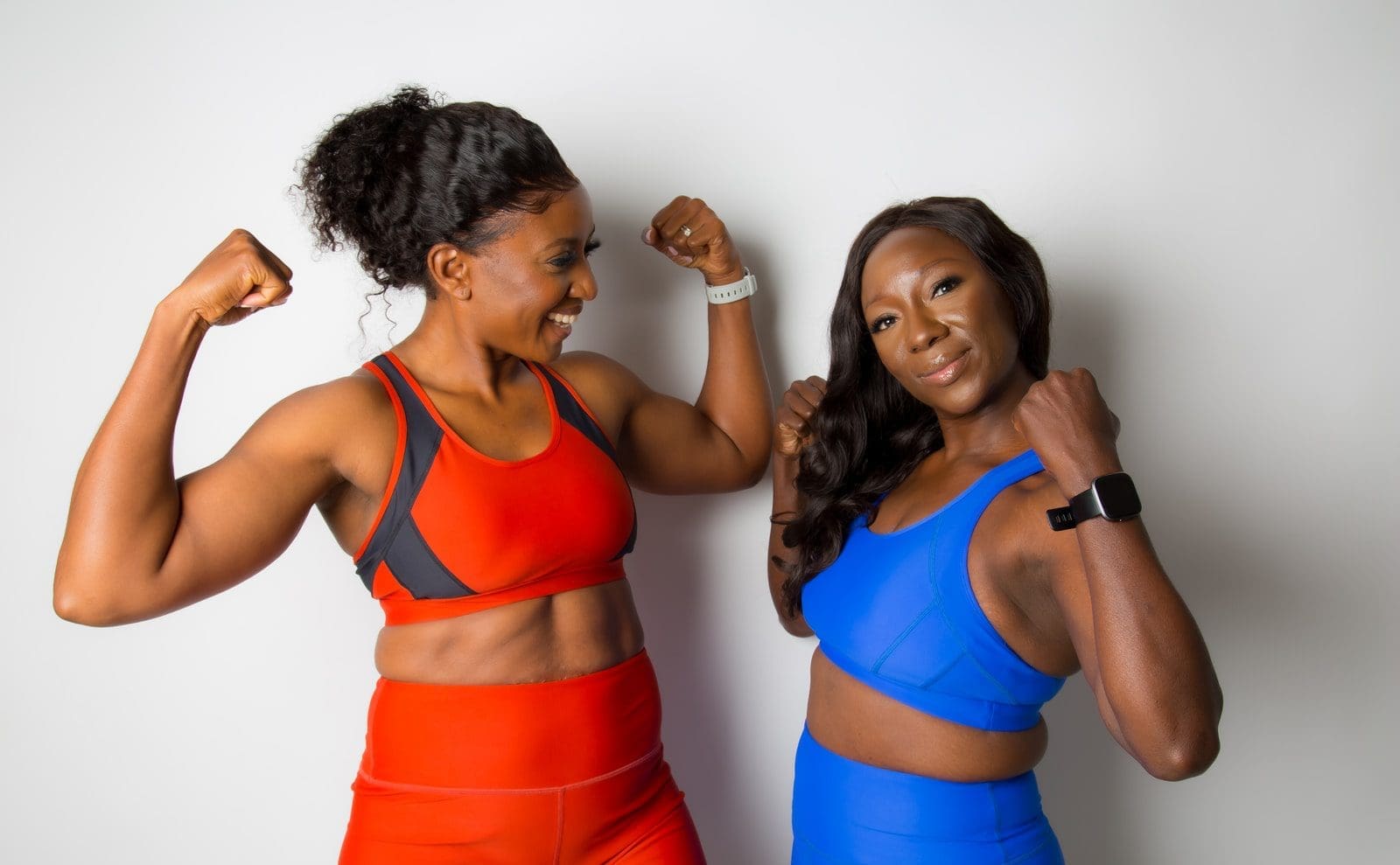effective sportswear woman in blue sports bra beside woman in blue sports bra