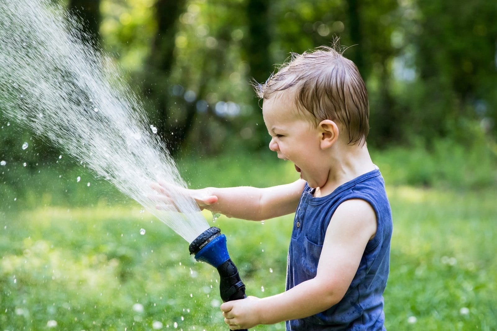 toddler playing water hose