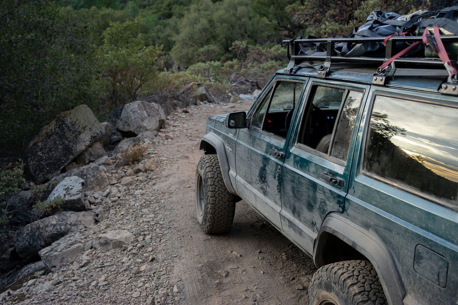 tub rack on white and black jeep wrangler on dirt road during daytime