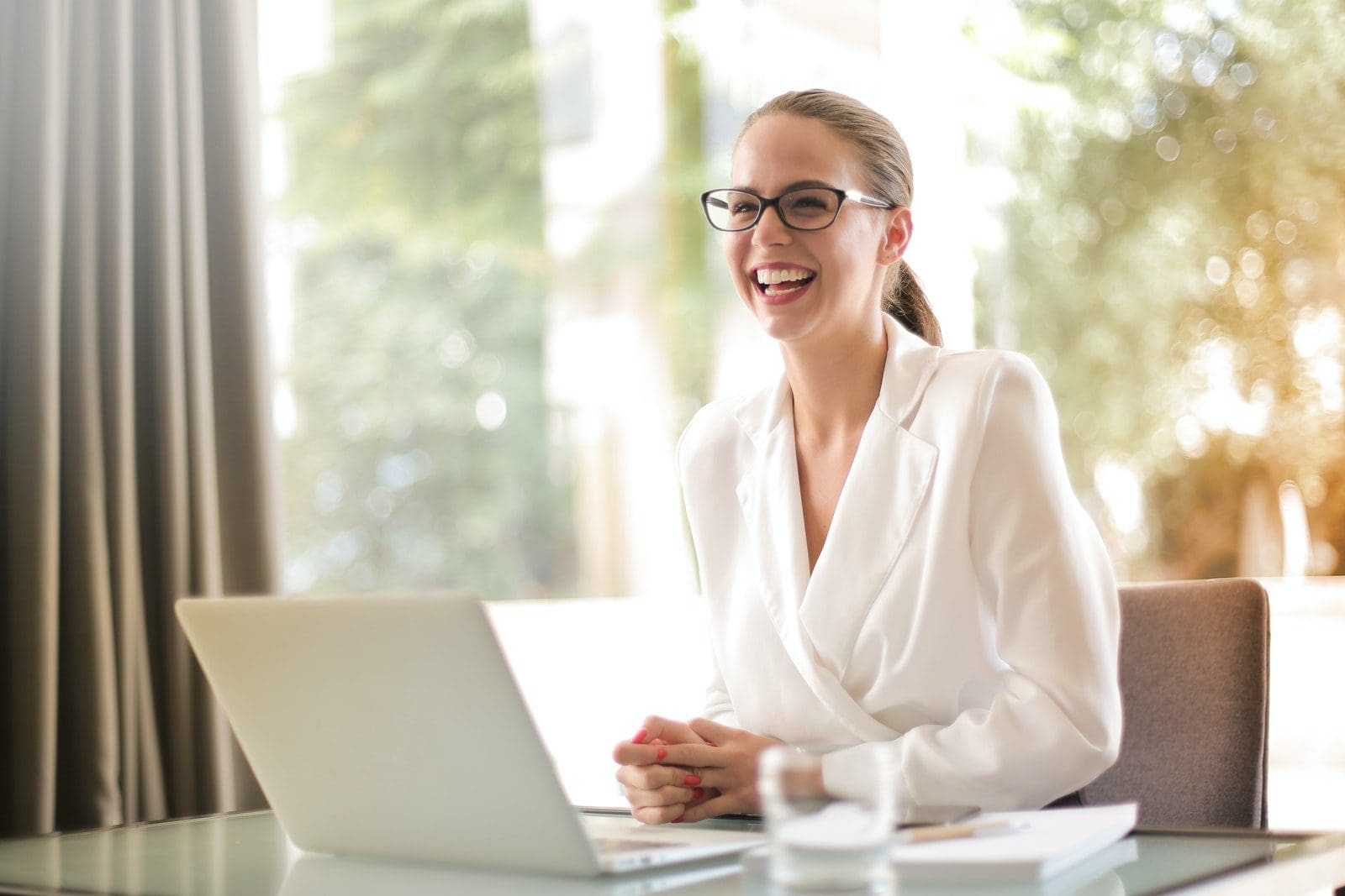 dream career Laughing businesswoman working in office with laptop