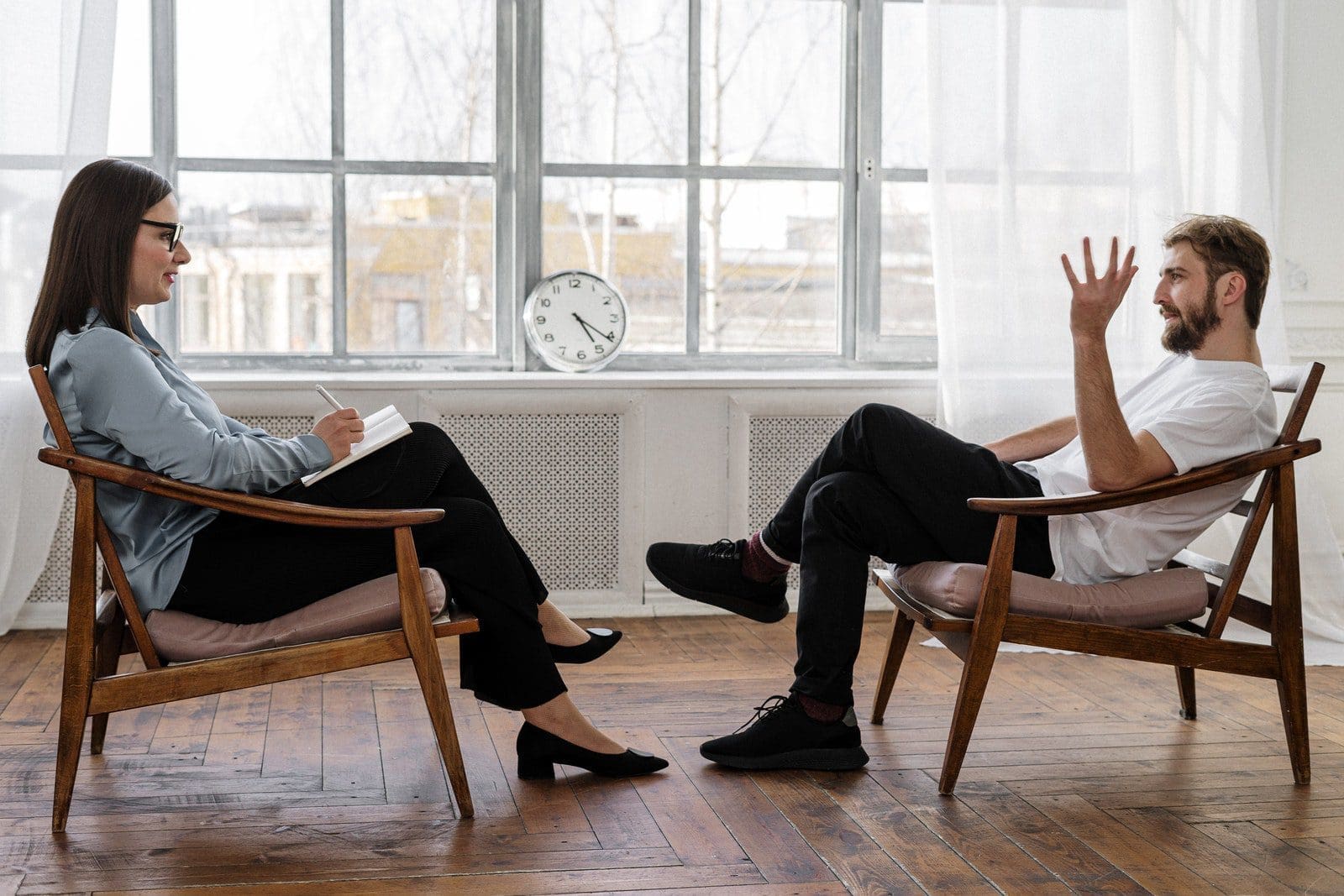 therapy practice Person in Black Pants and Black Shoes Sitting on Brown Wooden Chair