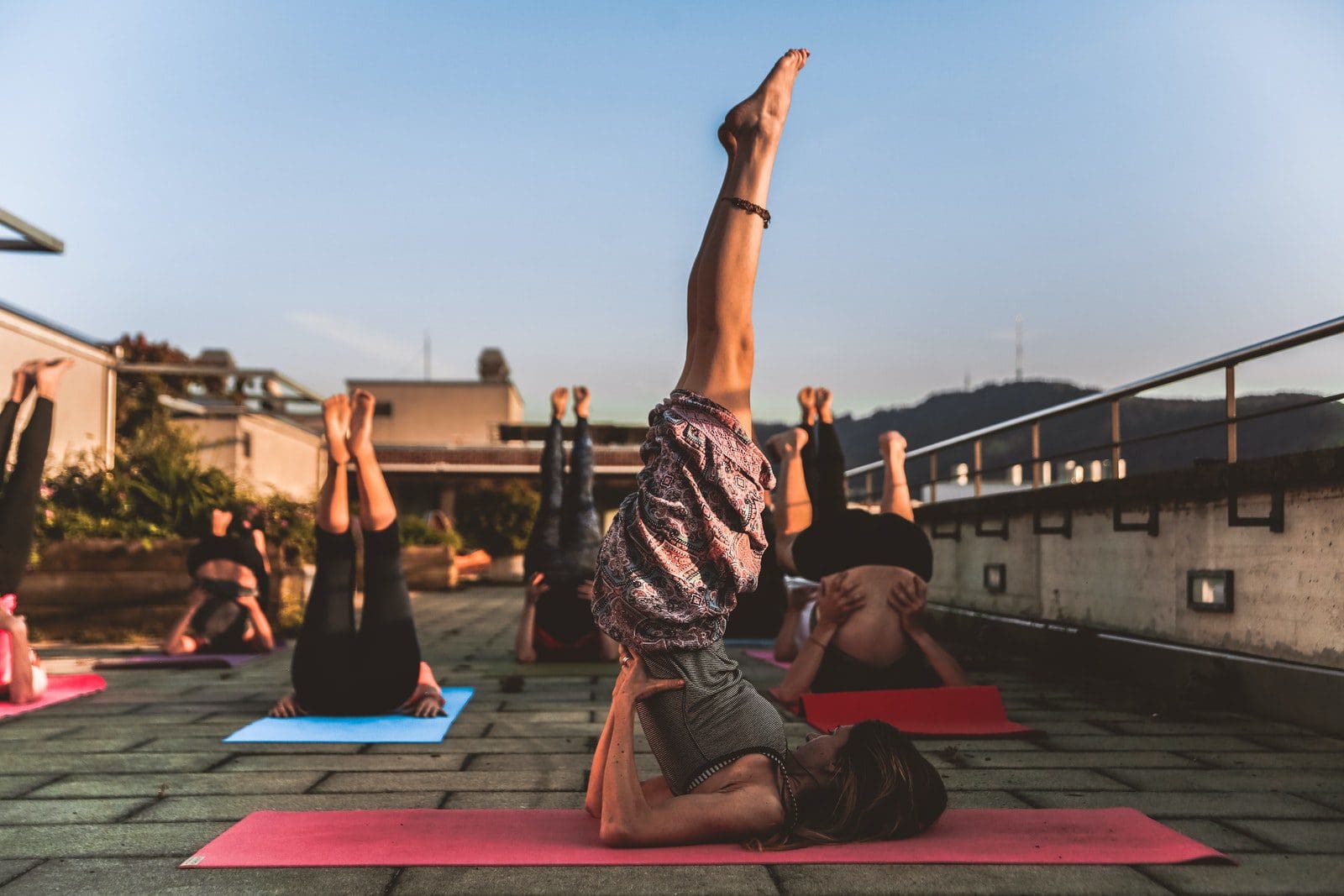 Photo by Amin Sujan yoga classes Group of Women Lying on Yoga Mat Under Blue Sky