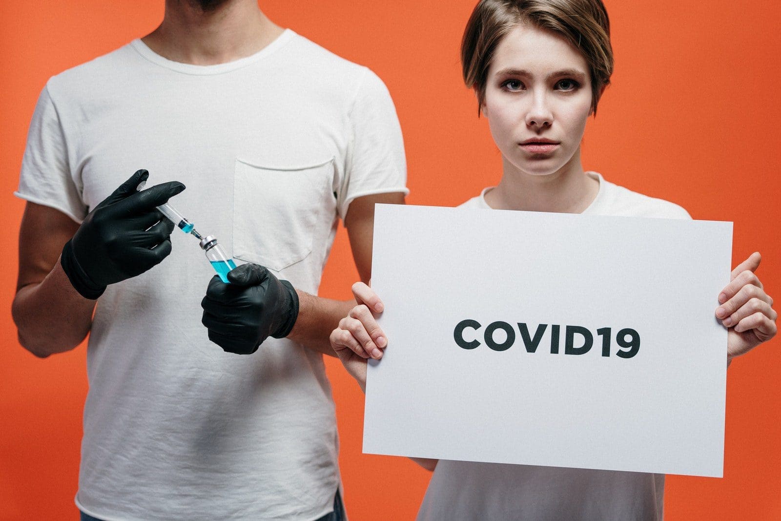 Nanobodies Man Holding A Vaccine With Woman Holding A Covid19 Poster