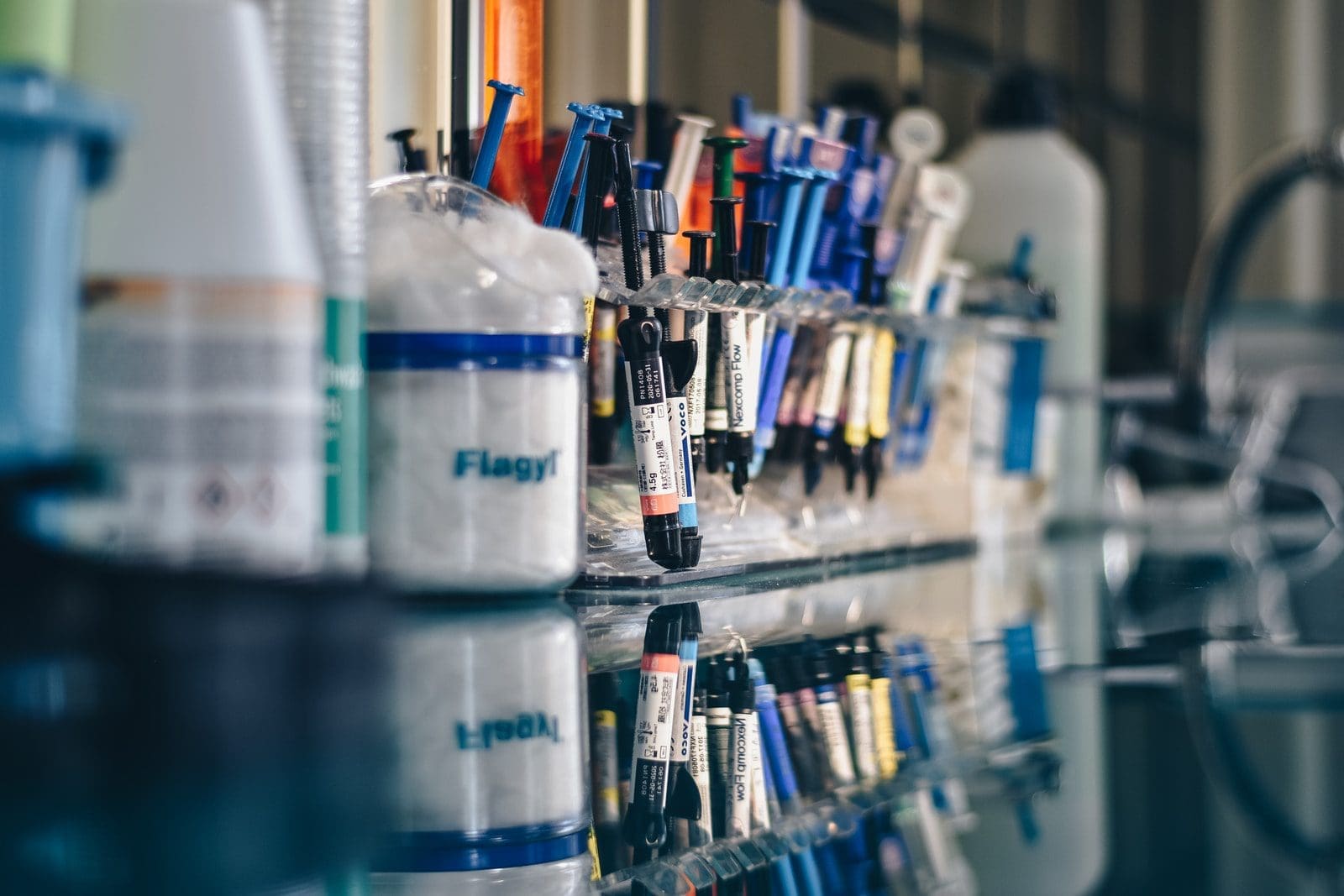 saliva test assorted-color syringes on clear glass rack