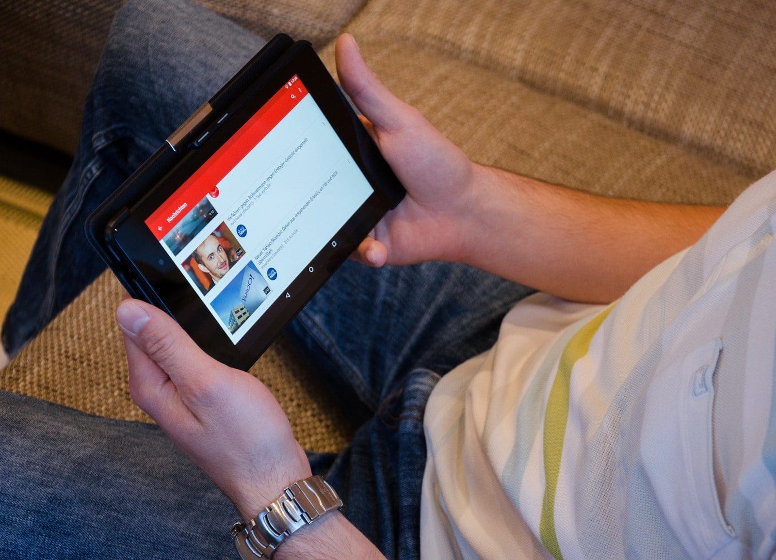 Person Holding Tablet Computer Showing Videos ads