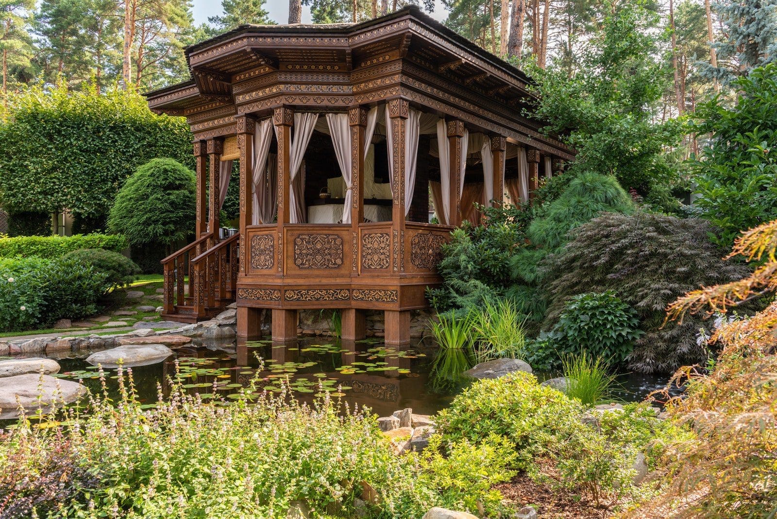 Brown Wooden Gazebo Surrounded by Green Trees and a Pond