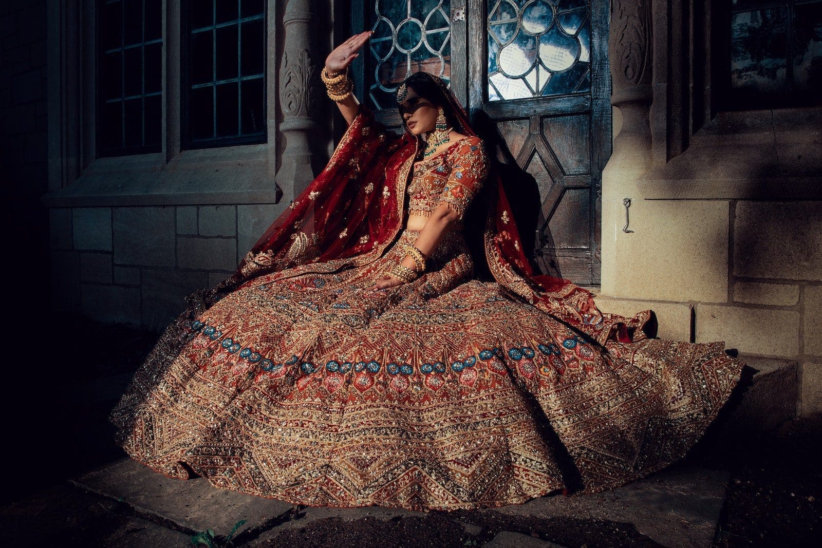 Woman in Red and Brown Dress Sitting in Front of the Door