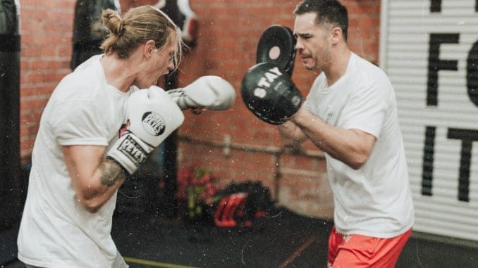 two men sparring inside boxing gym