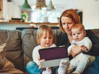 Tips For Finding Support As A Single Parent 3 two babies and woman sitting on sofa while holding baby and watching on tablet