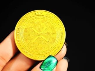 gold round coin on persons hand Ripple crypto