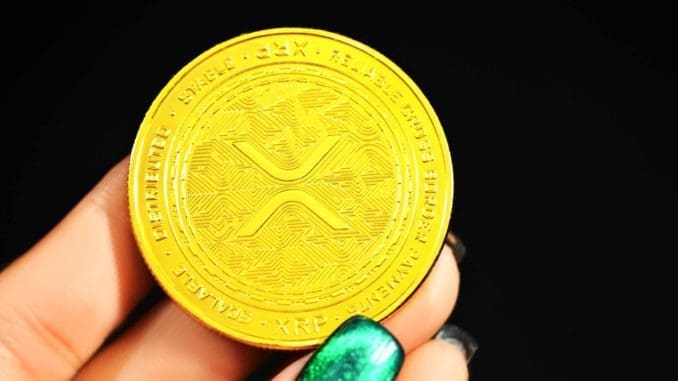 gold round coin on persons hand Ripple crypto