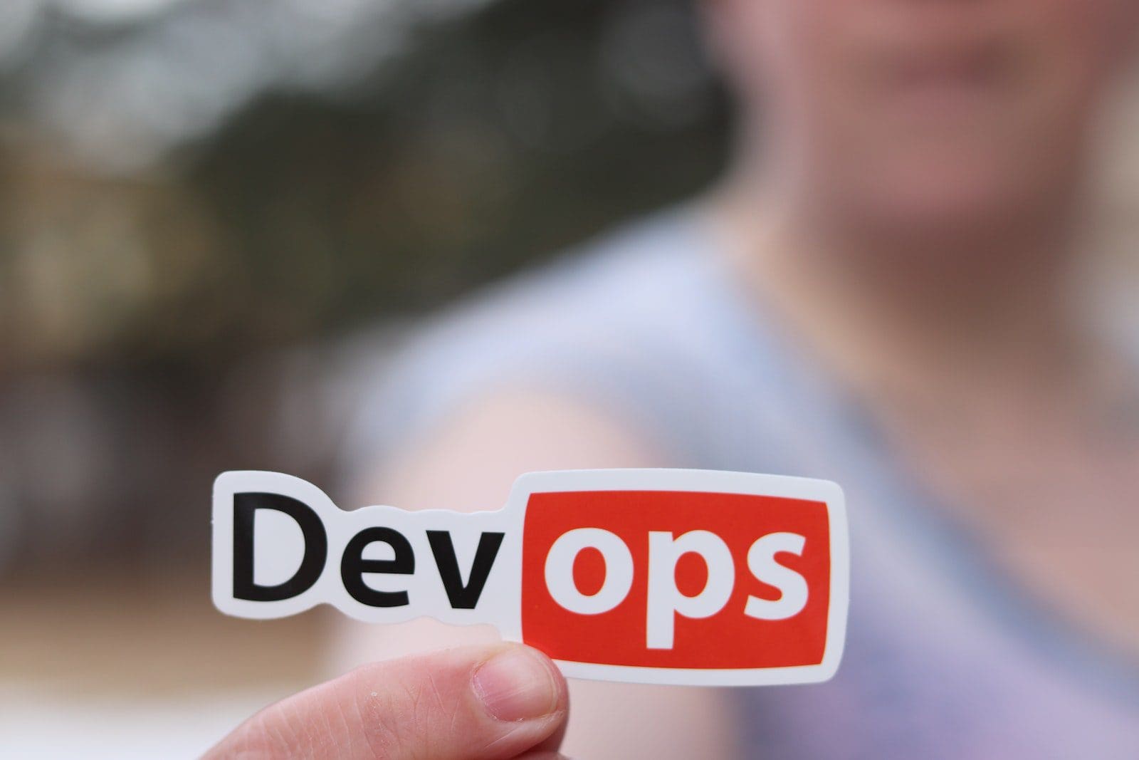 Person Holding a Sticker DevOps