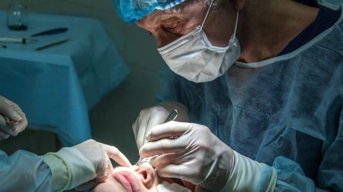 doctor conducting operation at patient in operating room cosmetic surgery