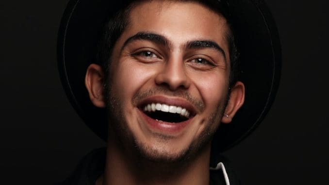 man in black and white nike zip up jacket smiling with a healthier smile