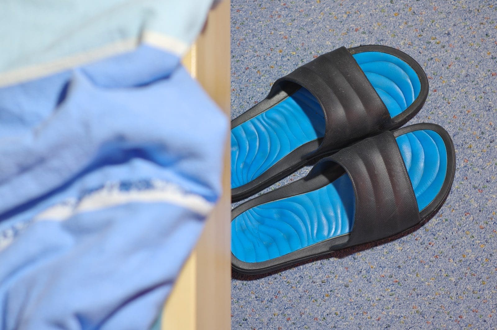 a pair of blue and black slippers sitting on top of a floor