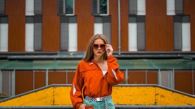 woman standing beside grill while holding sunglasses street style