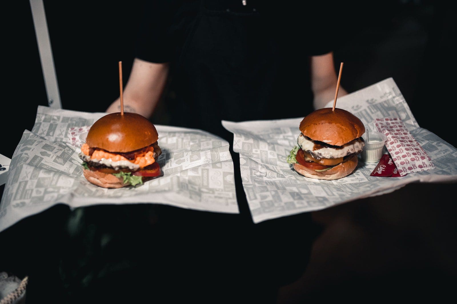 Kua Aina'S Secret Sauce: What Makes Their Burgers And Sandwiches So Special 2 Symmetrical View of a Waiter Carrying Two Burgers