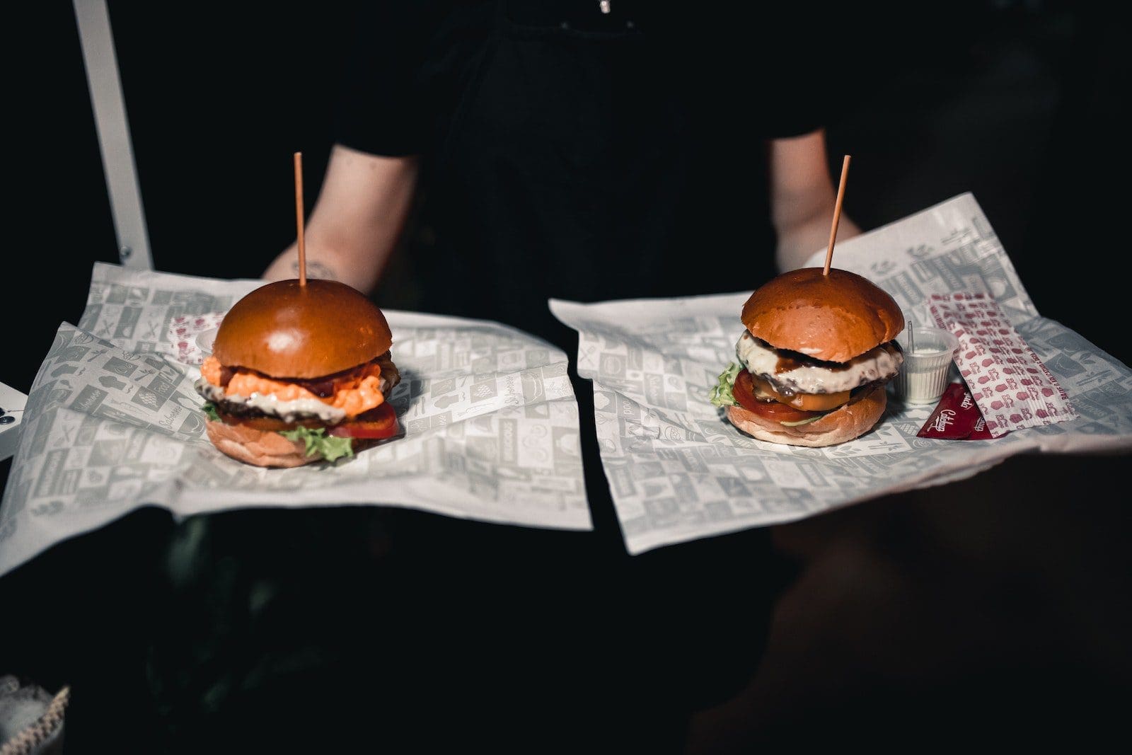 Symmetrical View of a Waiter Carrying Two Burgers