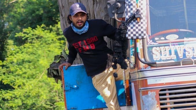 man in black long sleeve shirt and brown pants standing beside red truck during daytime