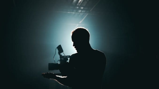 Silhouette of Man Standing in Front of Microphone