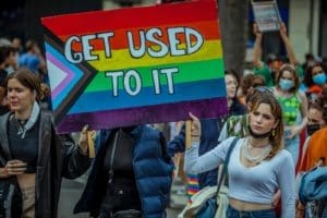 Things To Examine Instead Of Debating The Legalization Of Same-Sex Marriage 2 woman in white shirt holding purple and blue love print banner