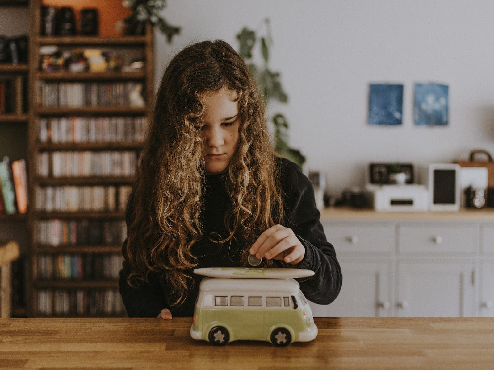 girl wearing black sweatshirt playing toy car stock investment emergency fund