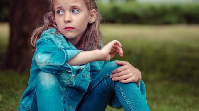 selective focus photography of girl sitting near tree teenage suicide